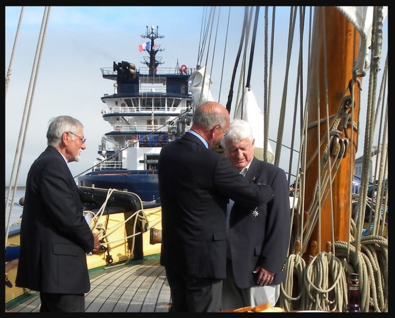 DR : Le décret du 15 janvier 2015 distingue Hervé Grall. Il est décoré sur le pont de la goélette La Recouvrance par Daniel Jégou, après l'éloge du président de la section du Mérite Maritime Finistère, Christian Wozniak.