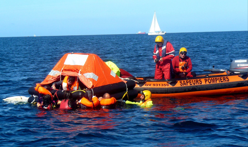 © Christian Wozniak :  sauvetage par les pompiers d'un équipage  à l'eau autour du radeau de survie en attente d'hélitreuillage.