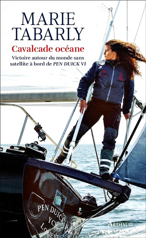 © photo de la couverture du livre Cavalcade océane. Marie Tabarly avec un pied sur le pont, un pied sur le support de pataras de l'artimon sur le tableau arrière de Pen Duick VI