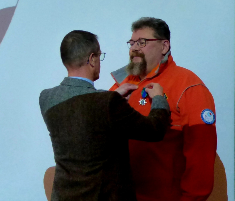 © Photo SNSM du Conquet : Le CA Frédéric de Damlaincourt Délégué Départemental du Finistère SNSM, remet la croix de Chevalier du Mérite Maritime à Laurent Devavry.