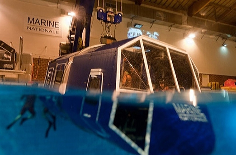 © Photo Marine nationale : exercice de simulation dans une cellule d'aéronef à moitié  immergée après un amerrissage forcé.